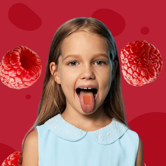 Young girl with a dissolvable vitamin strip on her tongue against a red background with raspberries