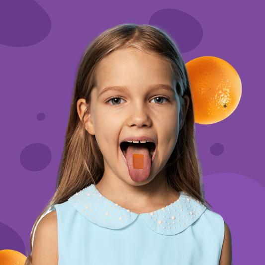 Young girl with a dissolvable vitamin strip on her tongue against a purple background with oranges